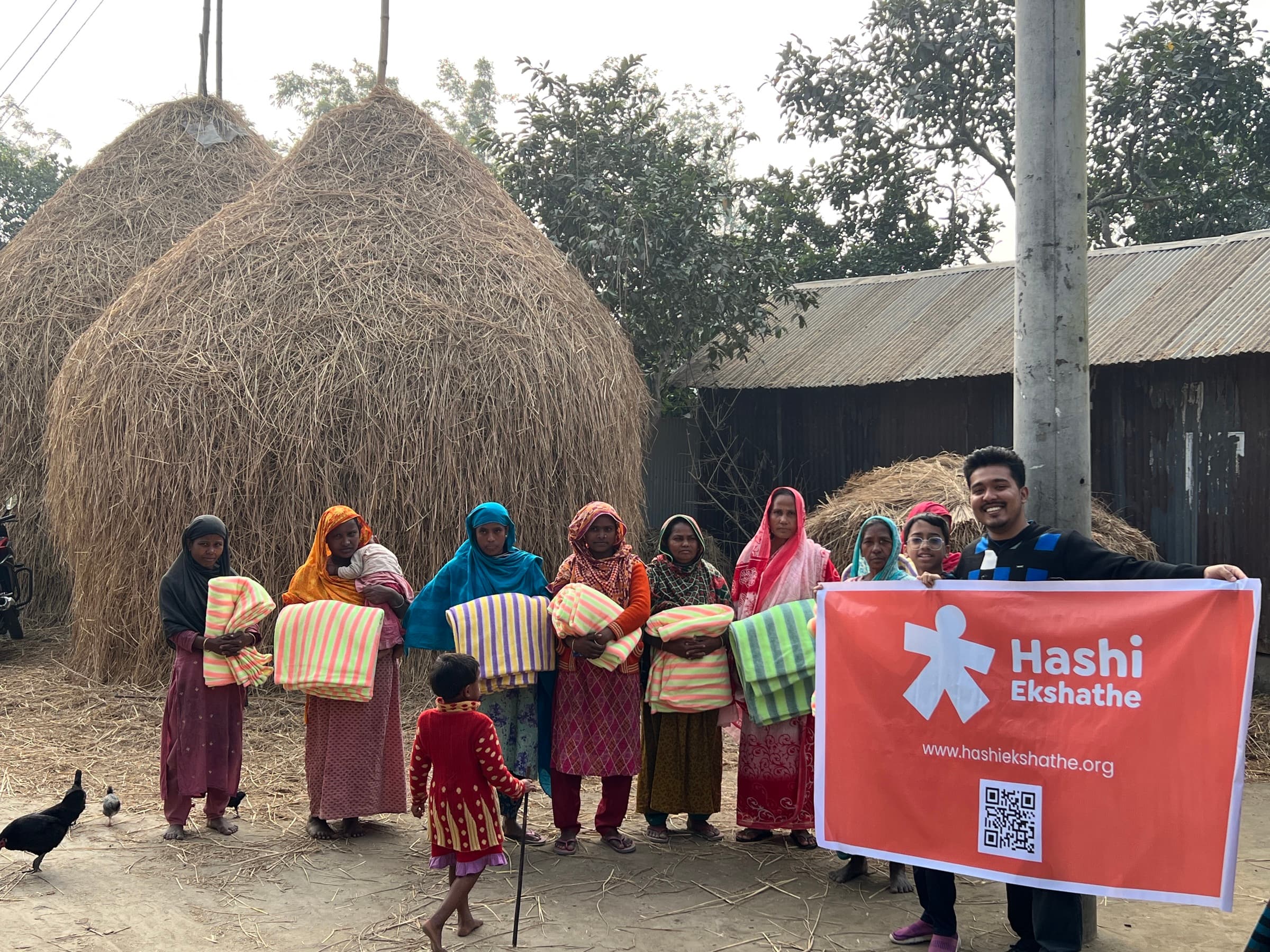 Families and volunteers with blankets during a winter distribution in Rangpur